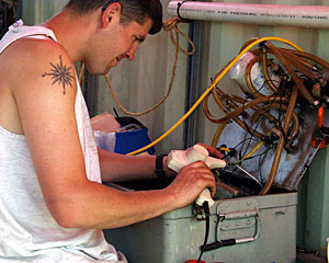 DSOG team member Peter Collins uses a heat gun to shrink insulation on electronics used in the ROV Jason.  