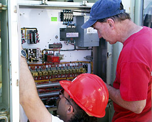 A snag with the winch power slows the launch of ROV Jason, but DSOG team member Craig Elder (left) and electrician John Donovan quickly resolve the problem. 