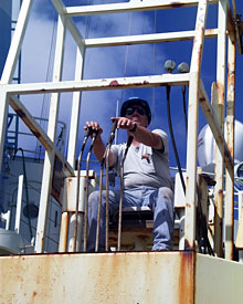  Bosun Alan Hopkins maneuvers the crane for moving equipment on the ship’s fantail.  