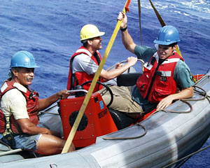 Ship crew members Kevin Butler, Pete Collins and Adam Seamans are hoisted back on board Knorr after retrieving the elevator.  