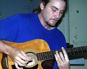 Graduate student RobbieYoung strummed Jesse Fuller’s song Monkey and the Engineer in his lab during a morning break.  