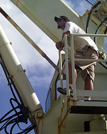 Seaman Mike Doherty waits on the starboard crane for Knorr’s arrival at the dredge site. He will operate the crane to launch the dredge, used to collect rocks on the seafloor.  
