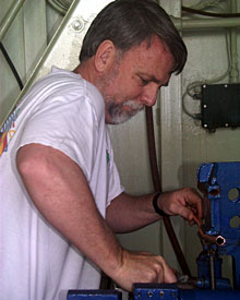Chemist Eric Olson crimps the ends of a length of copper tubing to hold a water sample taken from one of the CTD bottles. Back in the lab, this sample will be analyzed for its gas content.  