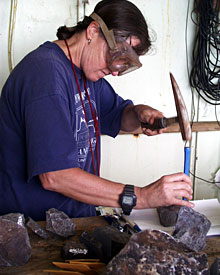 Geochemist Susan Humphris breaks rocks apart so she can describe and catalog them.  