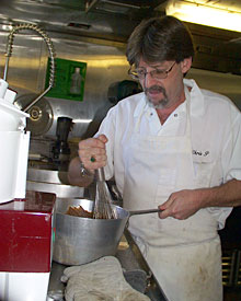 Cook Chris Poulin prepares molasses bread, part of tonight’s dinner. Chris and Steward Mirth Miller take turns baking fresh bread each day. 