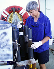 Microbiologist Anna-Louise Reysenbach removes a push core containing bacterial mat and sediment from the elevator.  