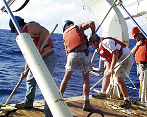 On the fantail are ship’s crew members (left to right) Jim McGill, Kevin Butler, Mike Doherty and Kent Sheasley bringing Medea back on board for the final time.  