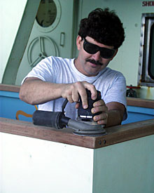Captain AD Colburn lends a hand by sanding the cap rail of the “pool.” We hope it will be filled tomorrow so we can test it.  