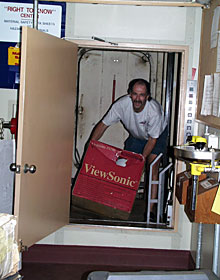 DSOG Team Member Craig Elder hauls boxes out of the ship’s elevator for packing. The elevator can travel to four decks on the ship.  