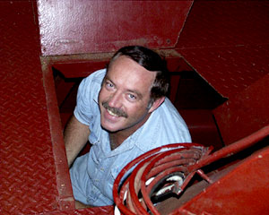  Alden Luallin, the Marine Electrician, emerges from a hatchway after completing his work below. 