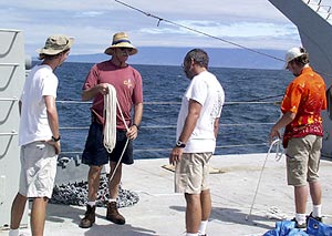 Gene Pillard, the Res. Tech. (holding rope), gives Ben Grosser (left), Joe Becker and Jeremy Haney a lesson in rope coiling, in preparation for tomorrow’s dredging.