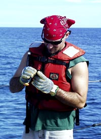 Steve Volpe closely examines a rock.  