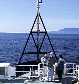 The view from Revelle’s fore deck early this morning. Volcán Ecuador forms the backdrop as Dan Jacobson (left) helps Francisco Cruz with his bird survey. 