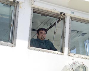 Joe Ferris, Third Mate, keeps a watchful eye from the bridge this morning and takes in the view of Isabela and Fernandina Islands.  