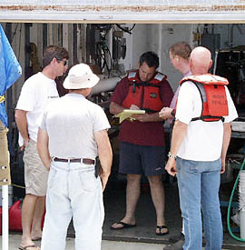 Captain Chris Curl, Dennis Barclay, Jack Healy, Ron Wheatley and Alden Luallin (clockwise) meet to discuss the results of their testing on the trawl winch. The engineering department has worked round-the-clock to repair the tensiometer so that we can continue our dredging program. This afternoon they put the finishing touches on the repairs and we intend to dredge the submarine east rift zone of Genovesa Island early tomorrow morning.