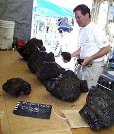 Mark Kurz sorts through rocks that have just come up in the dredge. It is important to catalogue all the samples carefully so none get lost or mixed up with those from another sampling site.  