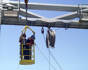In order to pull up the broken wire, Vic Barnhart, Bosun, and Jim Pearson, Able Seaman, had to attach an extra block on the A-frame. This will allow the wire to be hauled up using the capstan on the fan-tail.