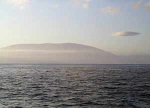 The sunrise over Cerro Azul volcano on Isabela Island. Note the ‘flying-saucer’ cloud at upper right. 