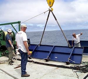 Bent back into shape, chipped and re-painted - the port bullwark was finally moved into place on the fan tail. Eric Wakeman (left), Chief Mate, Ron Wheatley, Chief Engineer, and Victor Barnhart, Bosun use the ships cranes to move the large panel.