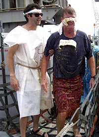  Big Red Petro (Dennis Geist) emerges from the ceremony to be cleansed by a Noble Shellback (Josh Curtice).