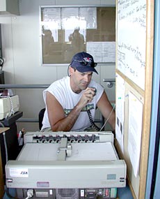 Alvin Pilot Bruce Strickrott keeps in communication with the submersible as it explores the ocean floor. In front of him, a plotter maps Alvin’s track across the seafloor today.