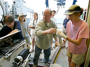  Stace Beaulieu and Tim Shank transfer a tubeworm, about 3 feet long, from the basket into a waiting bucket of water.