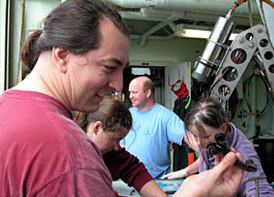 Another prize. Chief Scientist Jess Adkins rejoices with a spectacular coral fossil of Desmophyllum Cristagalli. "It's one of the largest I've ever seen," he said. Scientists Kate Buckman, Tim Shank, and Rhian Waller go through the collection basket behind him.