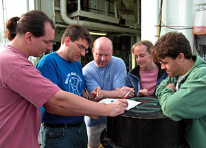 Scientist Tim Shank inspects Alvin's dive basket, which is used to transport samples from below the ocean surface back to the ship. Alvin uses its two mechanical arms to collect organisms in the white mesh nets visible in this photograph. The sub then dumps those nets into its main basket.