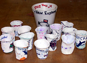 Deep-sea art. In the background is a normal-size Styrofoam coffee cup. The others used to be normal size, but after a trip to the seafloor with Alvin, they were deformed by the intense pressure of the water. These cups are from the families of the workers at the Microbiology Lab, North Devon District Hospital, U.K.