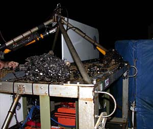 A late-night shot of the towed camera sled, with a large chunk of Desmophyllum cristagalli on top. The coral was inadvertently caught there after the tow-cam got stuck on a ledge last night.  