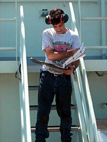 Oiler Mike Spruill looks over mechanical reports. Much of the oilers' work is behind the scenes. They work in the engine room, tending to the guts of the ship, and on deck performing a variety of other maintenance tasks.