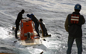 Three swimmers accompanied the sub’s deployment this morning, instead of the usual two. Sean McPeak (kneeling) is training to work with Alvin, instruction that takes at least 18 months. With Sean on his first swim are Raul Martinez and Mark Spear. Gavin Eppard stands by.