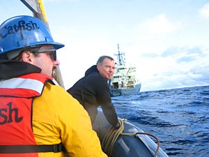 Research vessel Atlantis from the Alvin recovery boat. Aiding in the sub’s recovery is seaman Ed Popowitz (in hardhat) and Carl Wood, the ship’s steward who is also a certified Alvin swimmer. (Photo by Mark Spear).