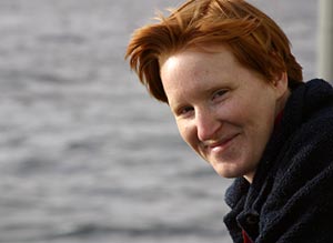 Mark Spear, a mechanical technician with the Alvin crew, prepares a transponder for dropping overboard. Transponders act as beacons to guide the submersible while exploring the seafloor. The hard yellow plastic case helps protect a glass ball, hydrophone, and computer panel inside.