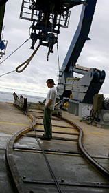 After Alvin launches daily around 8 a.m., scientists and crew desert the fantail, returning to their labs and work projects. Sean McPeak, an electrical technician and Alvin pilot in training, lingers on the tracks used to move the sub between its hangar and the ship’s A-frame.