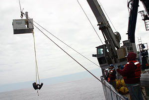 Bosun Wayne Bailey (foreground) and Seaman Kevin Threadgold use a crane on the starboard side of the fantail to retrieve a current meter deployed earlier in the cruise. This seafloor instrument measures the temperature, speed and direction of flow of bottom currents.