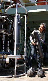 Kazumi Baba, a shipboard sciences services group technician, makes adjustments to bottles used on the CTD, an instrument that measures water conductivity (an indicator of how salty it is), temperature, and depth in the ocean.