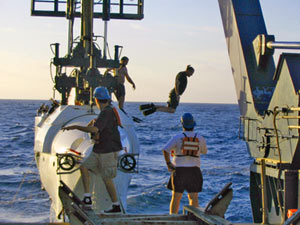 As Alvin is hoisted aboard, Alvin pilot in training Mark Spear�who is certified to help recover the sub�leaps into the Pacific.