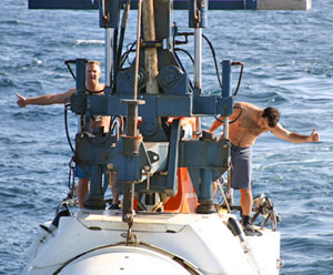 Steward Carl Wood (left) and Alvin pilot Anthony Tarantino give the sign that the submersible has cleared the ship, and is ready to be lowered. (Photo by Amy Nevala)