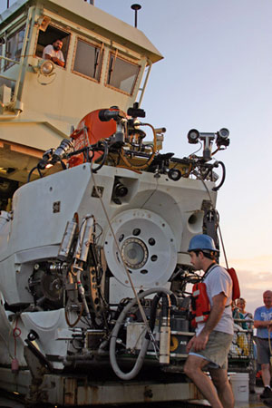 Pilot Tony Tarantino examines Alvin after today�s dive. Above Alvin is the �dog house,� where an engineer controls the A-frame to launch and recover the sub. (Photo by Amy Nevala)