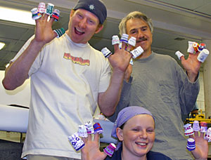 Scientists Adam Soule (left), Dan Fornari, and Rhian Waller show off shrunken plastic foam cups decorated by first and sixth grade classes at Grace-St. Luke�s Episcopal School in Memphis, Tenn. Alvin carries the coffee cups in a mesh bag attached to the outside of the sub, where they compress under pressure at depth.