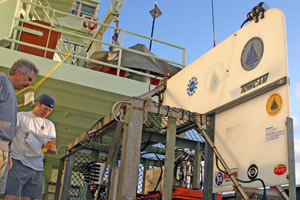 Geologist Dan Fornari and volcanologist Adam Soule prepare the towed camera system for nighttime operations. The camera is towed 100 to 300 meters (328 to 984 feet) behind the ship at 1/4 to 1/2 knot, the equivalent of walking at a leisurely pace.