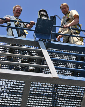 Oiler Allen Farrington (left) and engineer Keith Strand wear safety harnesses when working 60 feet (20 meters) above the deck doing weekly maintenance on the ship’s A-frame, used for launching and recovering Alvin each day.