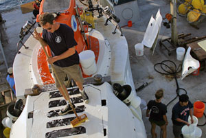 6. Pilot Gavin Eppard scrubs the top of Alvin to remove dried-on salt and grime that has accumulated during our expedition. (Photo by Amy Nevala)