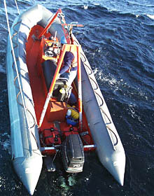 Atlantis' work boat is lowered into the water for the Alvin launch. The boat will pick up the swimmers once they have removed the lines from Alvin.  