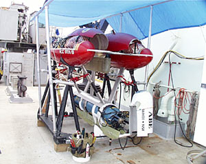 ABE on deck with its upper red pontoons open showing the glass balls that provide buoyancy. 