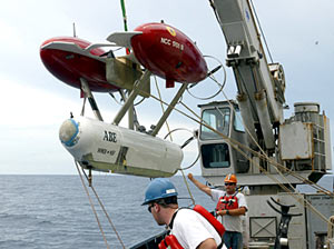 The ship’s crew lifts ABE over the side and lowers it into the ocean for a dive. 